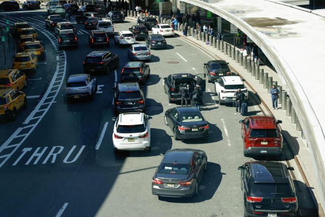 Cars line up at arrivals area at Newark Liberty International Airport in Newark, New Jersey, on March 18, 2026. US airport security officers missed their first full paycheck on March 13 as a partial funding shutdown of the government approached the one-month mark, with no breakthrough in a congressional standoff that is beginning to disrupt travel across the country. The lapse in funding is forcing thousands of Transportation Security Administration (TSA) staff to work without pay as spring travel picks up, raising fears of staffing shortages, longer security lines and flight delays. (Photo by kena betancur / AFP)