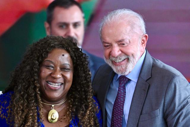 Brazil’s President Luiz Inacio Lula da Silva (R) and his Minister of Human Rights Macae Evaristo smile during a ceremony for the signing of the new Digital Statute for Children and Adolescents, which aims to restrict access to social media, at the Planalto Palace in Brasнlia on March 18, 2026. (Photo by Evaristo Sa / AFP)
