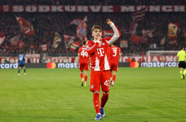 Bayern Munich's German midfielder #42 Lennart Karl celebrates scoring the 3-0 goal with his teammates during the UEFA Champions League, Round of 16 2nd-leg football match between FC Bayern Munich and Atalanta in Munich, southern Germany, on March 18, 2026. (Photo by Alexandra BEIER / AFP)