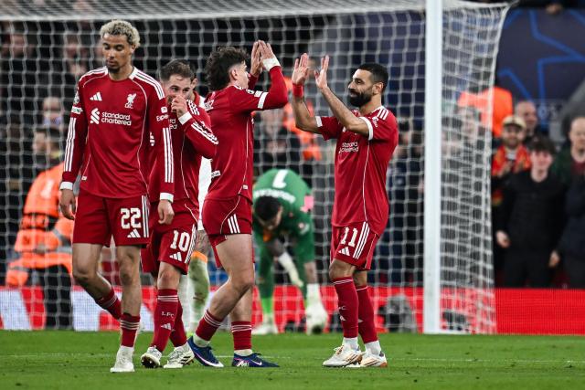 Liverpool's Egyptian forward #11 Mohamed Salah (R) celebrates scoring his team's fourth goal during the UEFA Champions League, round of 16 second leg football match between Liverpool and Galatasaray at Anfield in Liverpool, north-west England on March 18, 2026. (Photo by Paul ELLIS / AFP)