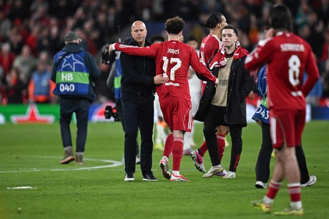 Liverpool's Dutch coach Arne Slot (L) greets Liverpool's English midfielder #17 Curtis Jones following the victory at the end of the UEFA Champions League, round of 16 second leg football match between Liverpool and Galatasaray at Anfield in Liverpool, north-west England on March 18, 2026. (Photo by Paul ELLIS / AFP)