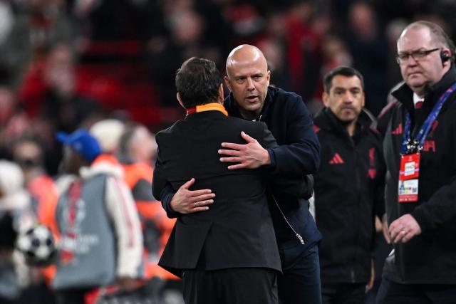 Liverpool's Dutch coach Arne Slot (C) greets Galatasaray's Turkish head coach Okan Buruk (L) at the end of the UEFA Champions League, round of 16 second leg football match between Liverpool and Galatasaray at Anfield in Liverpool, north-west England on March 18, 2026. (Photo by Paul ELLIS / AFP)