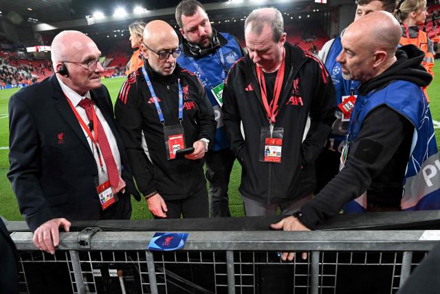 Liverpool officials inspect the fence against which Galatasaray's Dutch forward #77 Noa Lang sustained an injury, at the end of the UEFA Champions League, round of 16 second leg football match between Liverpool and Galatasaray at Anfield in Liverpool, north-west England on March 18, 2026. (Photo by Paul ELLIS / AFP)