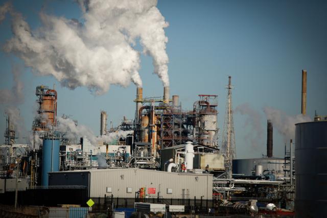 Smoke emanates from smokestacks from an oil refinery in Linden, New Jersey, on March 18, 2026. Oil prices surged Wednesday following a strike on a major Iranian gas facility as the Federal Reserve raised its inflation forecast while holding interest rates steady. (Photo by kena betancur / AFP)