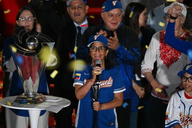 Venezuela's interim President Delcy Rodriguez speaks during an event to honor the national baseball team after its victory in the World Baseball Classic at the Miraflores Palace in Caracas on March 18, 2026. Venezuelan flags hang from windows, hundreds wear the national team’s jersey, and a holiday has been declared: the country woke up celebrating on March 18 after its first World Baseball Classic title, a celebration that some even link to the fall of Nicolas Maduro. (Photo by Juan BARRETO / AFP)