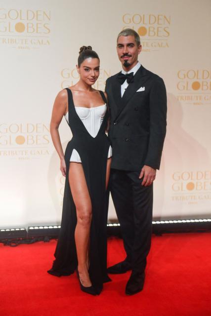 Brazilian actress Giovanna Lancellotti and LIESA (Rio de Janeiro Carnival Samba School League) president Gabriel David pose for photos on the red carpet during the Golden Globes Tribute Gala at the Copacabana Palace Hotel in Rio de Janeiro, Brazil on March 18, 2026. (Photo by Daniel RAMALHO / AFP)