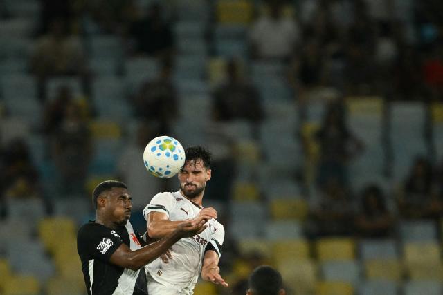 Vasco da Gama's midfielder #66 Cuiabano (L) and Fluminense's midfielder #08 Martinelli jump to head the ball during the Brasileirao Serie A football match between Vasco da Gama and Fluminense at the Maracana Stadium in Rio de Janeiro, Brazil, on March 18, 2026. (Photo by MAURO PIMENTEL / AFP)