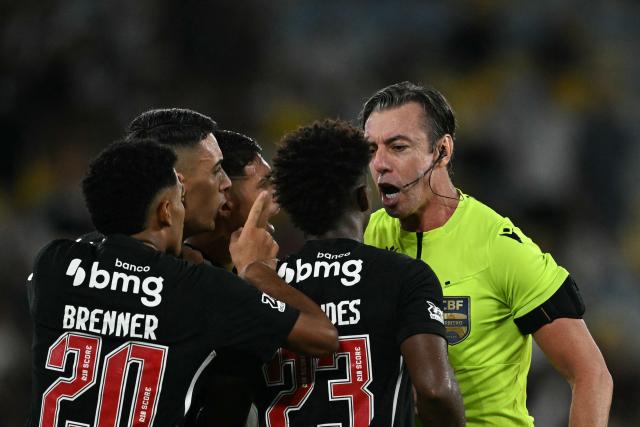Brazilian referee Raphael Claus argues with Vasco da Gama players during the Brasileirao Serie A football match between Vasco da Gama and Fluminense at the Maracana Stadium in Rio de Janeiro, Brazil, on March 18, 2026. (Photo by MAURO PIMENTEL / AFP)
