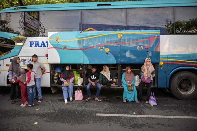 People wait to go to their home towns next free buses provided by the government to their home towns ahead of Eid al-Fitr, which marks the end of the Muslim fasting month of Ramadan in Surabaya on March 19, 2026. (Photo by JUNI KRISWANTO / AFP)