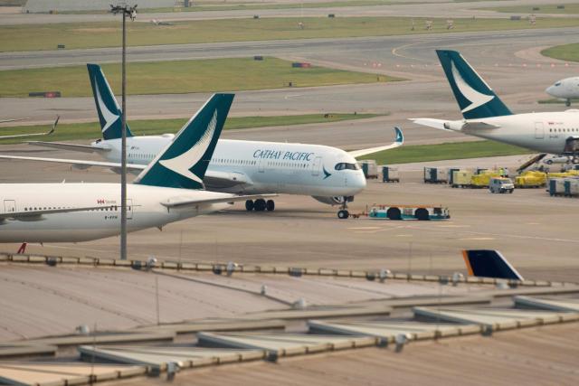 (FILES) In this photo taken on August 7, 2018, Cathay Pacific Airways passenger jets are seen on the tarmac at Hong Kong's international airport. Hong Kong aviation giant Cathay Pacific has suspended flights to and from Dubai until the end of April over the war in the Middle East, the company said in a statement on march 19, 2026. (Photo by Anthony WALLACE / AFP)