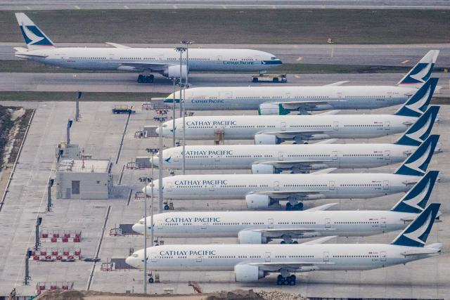 (FILES) A Cathay Pacific passenger airplane (top) is taxied onto the runway as other aircrafts belonging to the local flagship carrier are seen parked on the tarmac at Hong Kong's Chek Lap Kok International Airport on March 10, 2020. Hong Kong aviation giant Cathay Pacific has suspended flights to and from Dubai until the end of April over the war in the Middle East, the company said in a statement on march 19, 2026. (Photo by Anthony WALLACE / AFP)