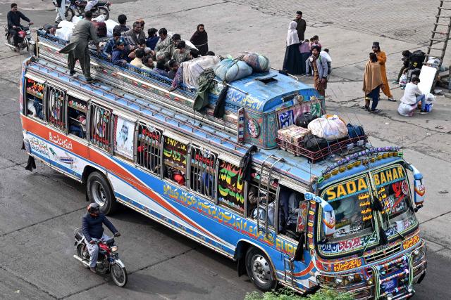 Muslims ride an overcrowded bus while returning to their hometowns ahead of Eid al-Fitr, which marks the end of the Islamic holy fasting month of Ramadan, in Lahore on March 19, 2026. (Photo by Arif ALI / AFP)