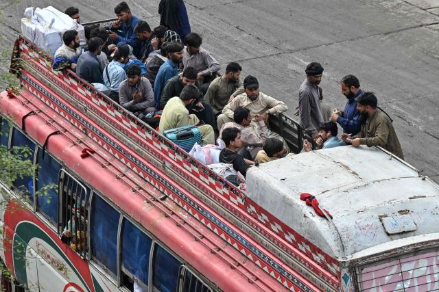 Muslims ride an overcrowded bus while returning to their hometowns ahead of Eid al-Fitr, which marks the end of the Islamic holy fasting month of Ramadan, in Lahore on March 19, 2026. (Photo by Arif ALI / AFP)