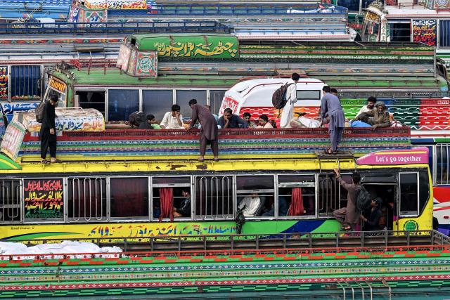 Muslims board atop a bus while returning to their hometowns ahead of Eid al-Fitr, which marks the end of the Islamic holy fasting month of Ramadan, in Lahore on March 19, 2026. (Photo by Arif ALI / AFP)
