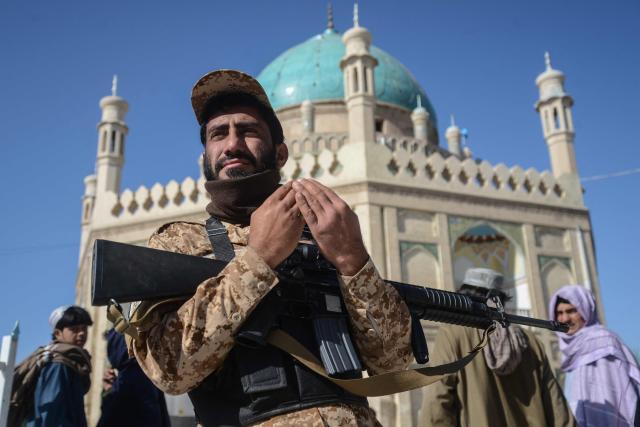 A Taliban security personnel offers Eid al-Fitr prayers, which marks the end of the holy fasting month of Ramadan, outside the Kharqa Sharif mosque in Kandahar on March 19, 2026. (Photo by Sanaullah SEIAM / AFP)