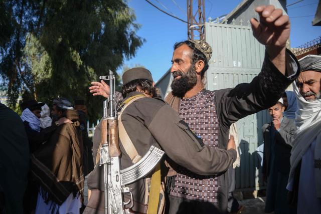 A Taliban security personnel (L) frisks Muslim devotees upon their arrival at the Kharqa Sharif mosque to offer Eid al-Fitr prayers, which marks the end of the holy fasting month of Ramadan in Kandahar on March 19, 2026. (Photo by Sanaullah SEIAM / AFP)