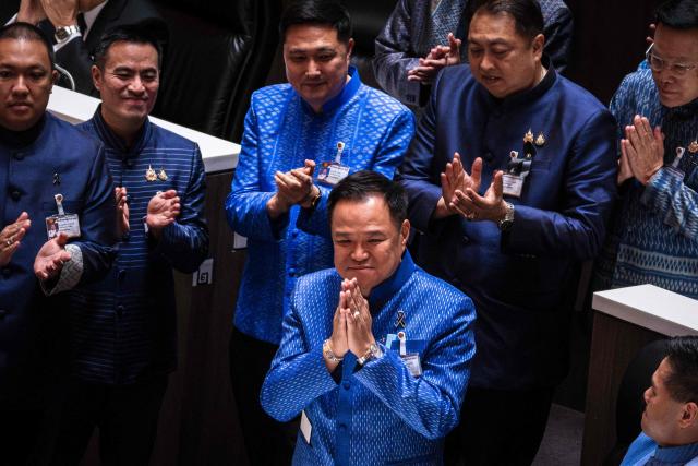 Thailand's caretaker Prime Minister and Bhumjaithai Party leader Anutin Charnvirakul (C) is applauded by fellow party members after a vote at Parliament in Bangkok on March 19, 2026. Thailand's new parliament elected Anutin Charnvirakul as prime minister, according to an AFP tally of the vote, keeping the conservative in the top office after his party routed its election rivals. (Photo by chanakarn LAOSARAKHAM / AFP)