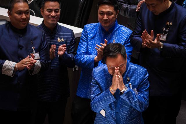 Thailand's caretaker Prime Minister and Bhumjaithai Party leader Anutin Charnvirakul (R) is applauded by fellow party members after a vote at Parliament in Bangkok on March 19, 2026. Thailand's new parliament elected Anutin Charnvirakul as prime minister, according to an AFP tally of the vote, keeping the conservative in the top office after his party routed its election rivals. (Photo by chanakarn LAOSARAKHAM / AFP)