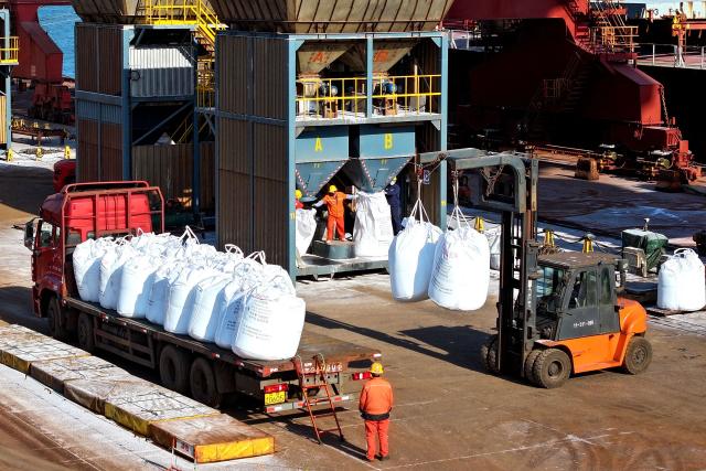 Fertilizer is loaded onto a truck after being unloaded from a ship at the port in Lianyungang, in China’s eastern Jiangsu province on March 19, 2026. (Photo by CN-STR / AFP) / China OUT