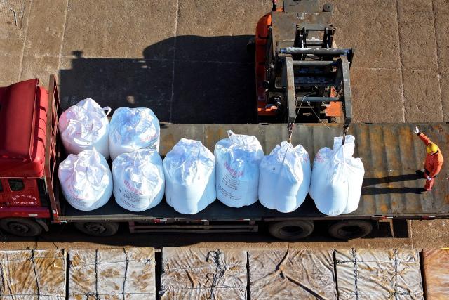 Fertilizer is loaded onto a truck after being unloaded from a ship at the port in Lianyungang, in China’s eastern Jiangsu province on March 19, 2026. (Photo by CN-STR / AFP) / China OUT