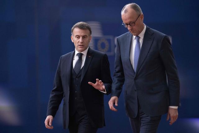 France's President Emmanuel Macron (L) and Germany's Chancellor Friedrich Merz arrive for a EU Summit at the EU headquarters in Brussels, on March 19, 2026. European Union leaders meet in the context of the US-Israeli war against Iran that is consuming the Middle East, and its consequences on energy prices and security. (Photo by JOHN THYS / AFP)