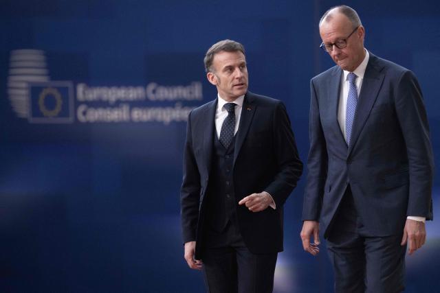 France's President Emmanuel Macron (L) and Germany's Chancellor Friedrich Merz arrive for a EU Summit at the EU headquarters in Brussels, on March 19, 2026. European Union leaders meet in the context of the US-Israeli war against Iran that is consuming the Middle East, and its consequences on energy prices and security. (Photo by JOHN THYS / AFP)