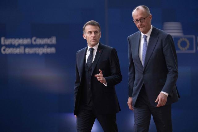 France's President Emmanuel Macron (L) and Germany's Chancellor Friedrich Merz arrive for a EU Summit at the EU headquarters in Brussels, on March 19, 2026. European Union leaders meet in the context of the US-Israeli war against Iran that is consuming the Middle East, and its consequences on energy prices and security. (Photo by JOHN THYS / AFP)