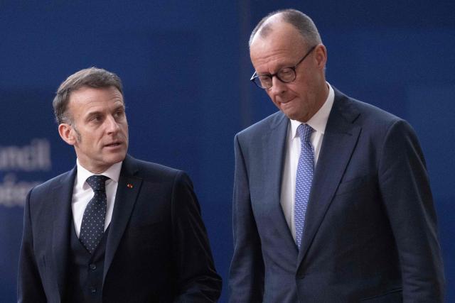 France's President Emmanuel Macron (L) and Germany's Chancellor Friedrich Merz arrive for a EU Summit at the EU headquarters in Brussels, on March 19, 2026. European Union leaders meet in the context of the US-Israeli war against Iran that is consuming the Middle East, and its consequences on energy prices and security. (Photo by JOHN THYS / AFP)