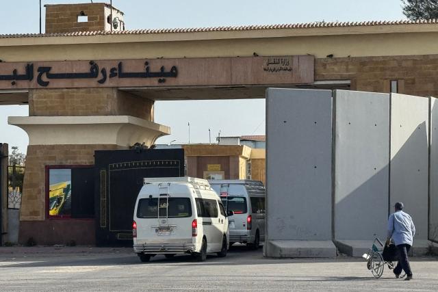 Minibuses carrying Palestinians wishing to return to the Gaza Strip line up on the Egyptian side of the Rafah crossing on March 19, 2026. Gaza's border crossing with Egypt reopened on March 19 for a limited number of people, Palestinian and Egyptian officials told AFP, for the first time since Israel and the United States launched strikes on Iran. (Photo by Amr ADEL / AFP)