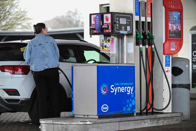 A customer fills up her car at a petrol service station in Huddersfield, northern England on March 19, 2026. Britain's energy minister warned petrol retailers on March 13 that the government would not tolerate "unfair practices" amid a row over rising fuel prices sparked by the Middle East war. European gas prices soared as much as 35 percent on March 19 as fresh strikes hit energy infrastructure in the Middle East, including Qatar's main gas facility. (Photo by Oli SCARFF / AFP)