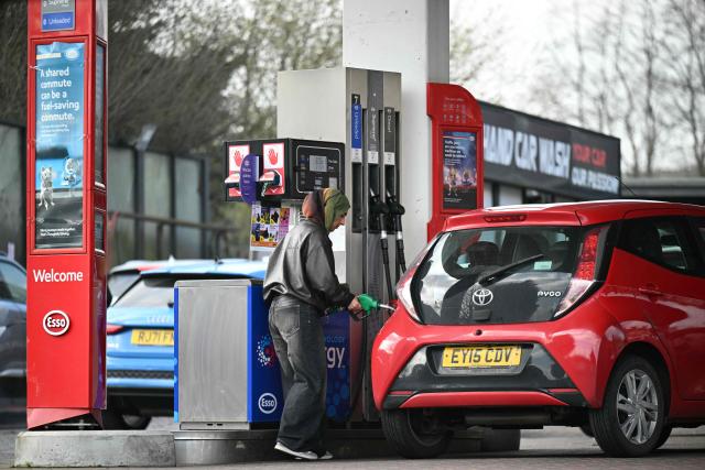 A customer fills up her car at a petrol service station in Huddersfield, northern England on March 19, 2026. Britain's energy minister warned petrol retailers on March 13 that the government would not tolerate "unfair practices" amid a row over rising fuel prices sparked by the Middle East war. European gas prices soared as much as 35 percent on March 19 as fresh strikes hit energy infrastructure in the Middle East, including Qatar's main gas facility. (Photo by Oli SCARFF / AFP)