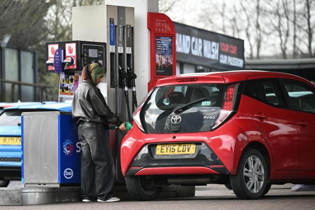 A customer fills up her car at a petrol service station in Huddersfield, northern England on March 19, 2026. Britain's energy minister warned petrol retailers on March 13 that the government would not tolerate "unfair practices" amid a row over rising fuel prices sparked by the Middle East war. European gas prices soared as much as 35 percent on March 19 as fresh strikes hit energy infrastructure in the Middle East, including Qatar's main gas facility. (Photo by Oli SCARFF / AFP)
