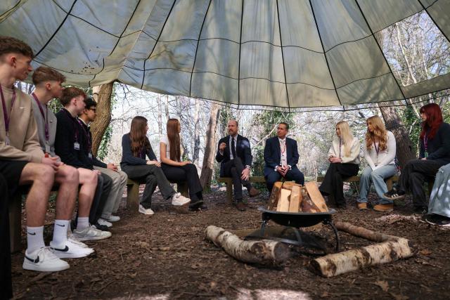 Britain's Prince William (C), Prince of Wales meets with principal Mark Avoth (4th R) and students during a visit to the Bourne Academy, a co-educational state-funded secondary school and sixth form in Bournemouth, southern England on March 19, 2026, to hear about pioneering youth schemes, supported by the Homewards programme, which work to stop homelessness. (Photo by Adrian DENNIS / POOL / AFP)