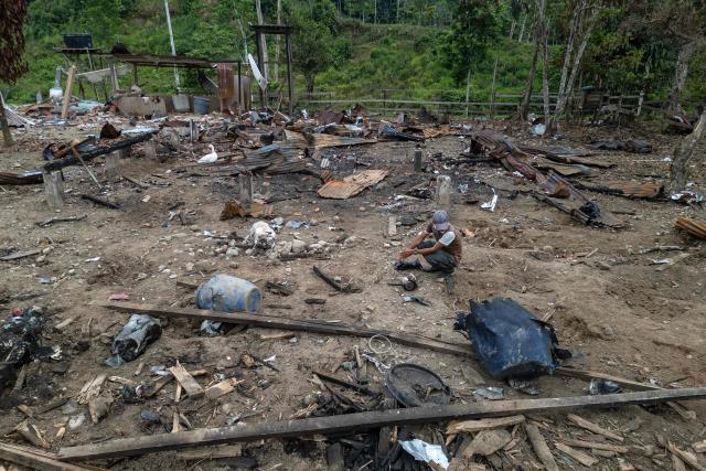 Aerial view of a farmer sitting amidst the rubble after a bomb was dropped by the Ecuadorean army in the Lago Agrio region, Sucumbios province, Ecuador, on the border with Colombia, on March 18, 2025. Reports from the Lago Agrio region in northern Ecuador have come to light after Colombian President Gustavo Petro reported on March 16, 2026, the discovery of an unexploded bomb belonging to the Ecuadorian army on his country’s territory. Ecuadorian President Daniel Noboa presented the operation to the press as the first airstrike in the “joint operations” with Washington against drug trafficking, announcing the destruction of an alleged training camp belonging to the Comandos de la Frontera, a Colombian guerrilla group. (Photo by Luis ACOSTA / AFP)