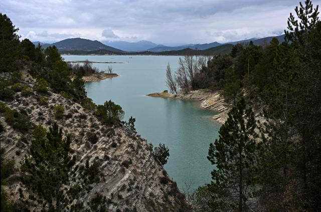 This photograph taken on March 19, 2026 shows a view of the Mediano reservoir amid high water level, in Mediano, Huesca province. This long-term project shows an inventory of several sites in Spain which are suffering from drought. Photos of the same places are taken every month over a very long period. (Photo by ANDER GILLENEA / AFP)