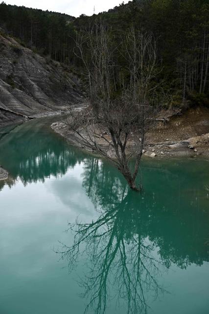 This photograph taken on March 19, 2026 shows a view of the Mediano reservoir amid high water level, in Mediano, Huesca province. This long-term project shows an inventory of several sites in Spain which are suffering from drought. Photos of the same places are taken every month over a very long period. (Photo by ANDER GILLENEA / AFP)