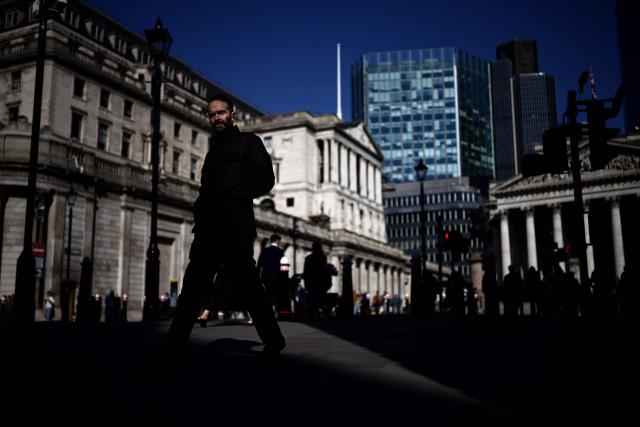 A pedestrian walks outside the Bank of England in central London on March 19, 2026. The Bank of England left its benchmark interest rate at 3.75 percent on March 19, as it monitors the inflation outlook, pressured by rising energy prices from the Middle East war. (Photo by Henry NICHOLLS / AFP)