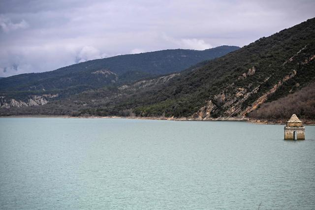 This photograph taken on March19, 2026 shows a view of the Mediano reservoir, with the Church of Asuncion of Mediano partially visible amid high water level, in Mediano, Huesca province. This long-term project shows an inventory of several sites in Spain which are suffering from drought. Photos of the same places are taken every month over a very long period. (Photo by ANDER GILLENEA / AFP)