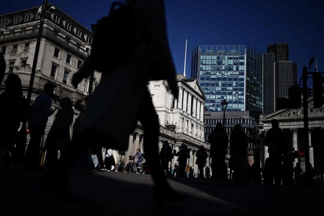 Pedestrians walk outside the Bank of England in central London on March 19, 2026. The Bank of England left its benchmark interest rate at 3.75 percent on March 19, as it monitors the inflation outlook, pressured by rising energy prices from the Middle East war. (Photo by Henry NICHOLLS / AFP)