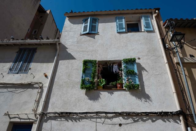 This photograph shows a window adorned with flowers in the Panier district, in Marseille, southern France, on March 19, 2026.  (Photo by Elodie CLEMENT / AFP)