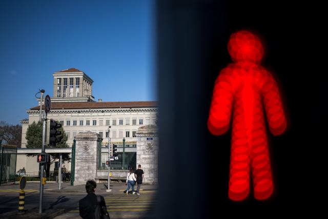 This photograph shows a traffic light next to the headquarters of the World Trade Organization (WTO) after the launch of their global trade outlook in Geneva, on March 19, 2026. The Middle East war could weigh heavily on already slowing global trade, the WTO warned saying merchandise trade volume growth could be as low as 1.4 percent this year, compared to 4.6 percent in 2025. (Photo by Fabrice COFFRINI / AFP)