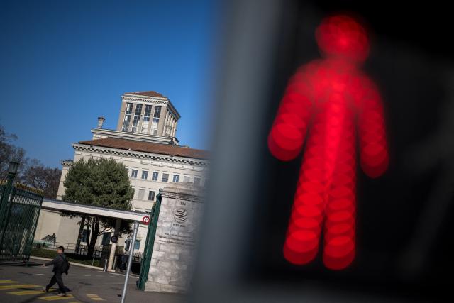 This photograph shows a traffic light next to the headquarters of the World Trade Organization (WTO) after the launch of their global trade outlook in Geneva, on March 19, 2026. The Middle East war could weigh heavily on already slowing global trade, the WTO warned saying merchandise trade volume growth could be as low as 1.4 percent this year, compared to 4.6 percent in 2025. (Photo by Fabrice COFFRINI / AFP)