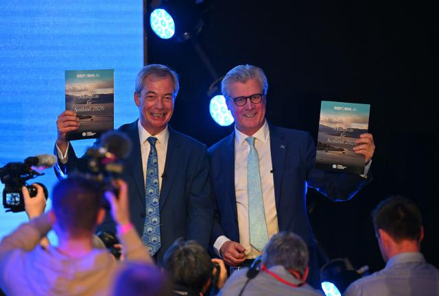 Reform UK leader Nigel Farage and Scottish leader Malcolm Offord pose with copies of the party's Scottish Manifesto, as they attend a press conference during its' 2026 Scottish Conference in Bishopton, suburban Glasgow, Scotland on March 19, 2026. (Photo by ANDY BUCHANAN / AFP)