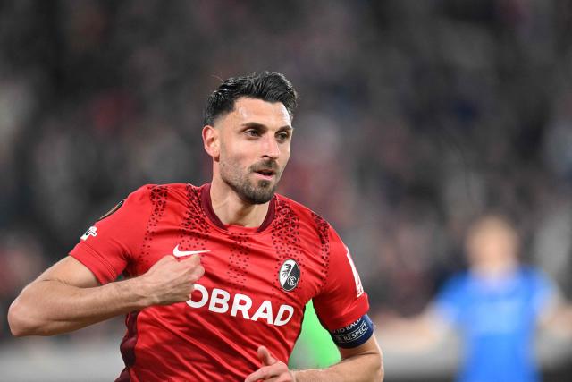 Freiburg's Italian midfielder #32 Vincenzo Grifo celebrates after scoring the 3-1 goal during the UEFA Europa League, last 16 second leg, football match between SC Freiburg and KRC Genk in Freiburg, southwestern Germany, on March 19, 2026.  (Photo by THOMAS KIENZLE / AFP)