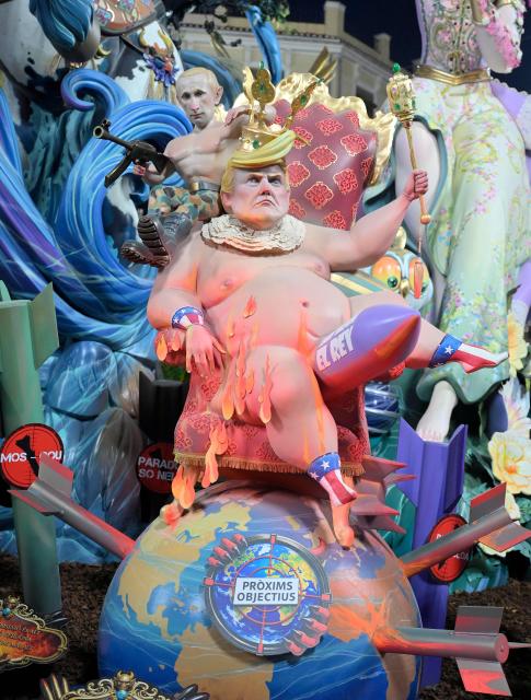 'Ninots' (cardboard figurines whose name literally means 'dolls' in Valencian language) depicting US President Donald Trump and Russian President Vladimir Putin, are pictured during the "Nit de la Crema" (the night of the burning) on the last night of the Fallas Festival in Valencia on March 19, 2026. The 'fallas' —gigantic cardboard structures depicting current events and celebrities, with individual figures known as 'ninots'— are burned in the streets of Valencia on March 19 as a tribute to Saint Joseph, the patron saint of the carpenters' guild." (Photo by Jose Jordan / AFP)