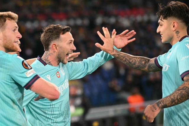 Bologna's Italian forward #10 Federico Bernardeschi (C) celebrates with teammates Bologna's Argentine forward #09 Santiago Castro (R) and Bologna's Italian midfielder #04 Tommaso Pobega after scoing a penalty during the UEFA Europa League last 16 2nd leg football match between AS Roma and Bologna at the Olympic Stadium in Rome on March 19, 2026. (Photo by Alberto PIZZOLI / AFP)