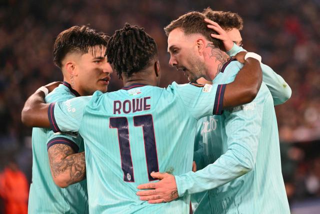 Bologna's Italian forward #10 Federico Bernardeschi celebrates with teammates Bologna's English forward #11 Jonathan Rowe and Bologna's Argentine forward #09 Santiago Castro after scoing a penalty during the UEFA Europa League last 16 2nd leg football match between AS Roma and Bologna at the Olympic Stadium in Rome on March 19, 2026. (Photo by Alberto PIZZOLI / AFP)