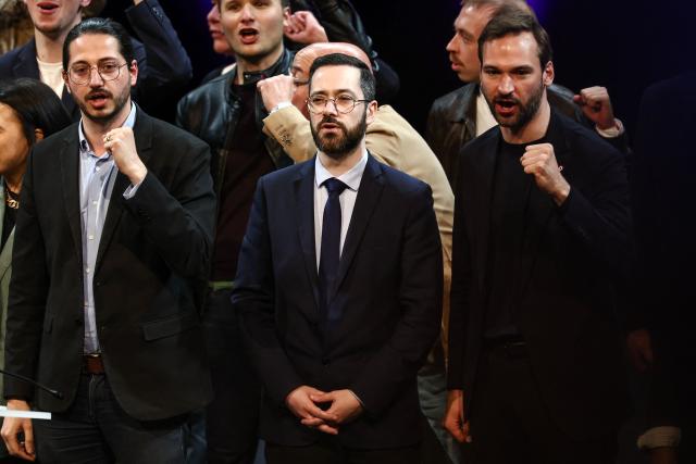 (From L) La France Insoumise - Nouveau Front Populaire's MP Aurelien Le Coq, La France Insoumise - Nouveau Front Populaire's MP David Guiraud and La France Insoumise - Nouveau Front Populaire's MP Ugo Bernalicis sing at the end of a campaign meeting in Lille, northern France, on March 19, 2026, ahead of the second round of France's 2026 municipal elections. French voters are scheduled to head to the polls for the second round of municipal elections on March 22, 2026. (Photo by Sameer AL-DOUMY / AFP)
