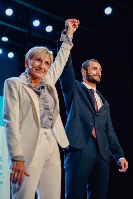Menton's first deputy candidate for the new right-wing list 'The Union!' (L'Union!) Louis Sarkozy (R) and mayoral candidate Sandra Paire wave to supporters during a campaign meeting in Menton, southern France on March 19, 2026, ahead of the second round of France's 2026 municipal elections. (Photo by Frederic DIDES / AFP)