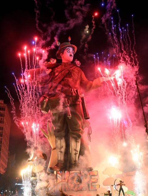 A 'ninot' (cardboard figurine whose name literally means 'doll' in Valencian language) depicting Charles Chaplin, burns during the "Nit de la Crema" (the night of the burning) on the last night of the Fallas Festival in Valencia on March 19, 2026. The 'fallas' —gigantic cardboard structures depicting current events and celebrities, with individual figures known as 'ninots'— are burned in the streets of Valencia on March 19 as a tribute to Saint Joseph, the patron saint of the carpenters' guild." (Photo by Jose JORDAN / AFP)